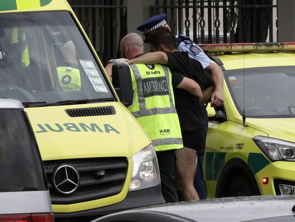 Police and ambulance staff help a wounded man from outside a mosque in central Christchurch, New Zealand, Friday, March 15, 2019. A witness says many people have been killed in a mass shooting at a mo ...