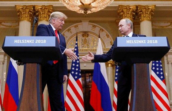 FILE PHOTO: U.S. President Donald Trump and Russia&#039;s President Vladimir Putin shake hands during a joint news conference after their meeting in Helsinki, Finland, July 16, 2018. REUTERS/Kevin Lam ...