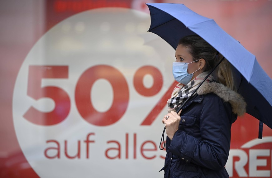 Frau mit Mundschutzmaske, Regenschirm, beim Shopping, SALE, Rabattschlacht, Preisnachlass, Corona-Krise, Baden-W