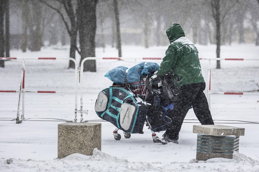 Ein Obdachloser mit einem Einkaufswagen, aufgenommen waehrend starken Schneefalls in Berlin, 08.02.2021. In der nordlichen Haelfte Deutschlands gibt es teils unwetterartige Schneefaelle und zweistelli ...