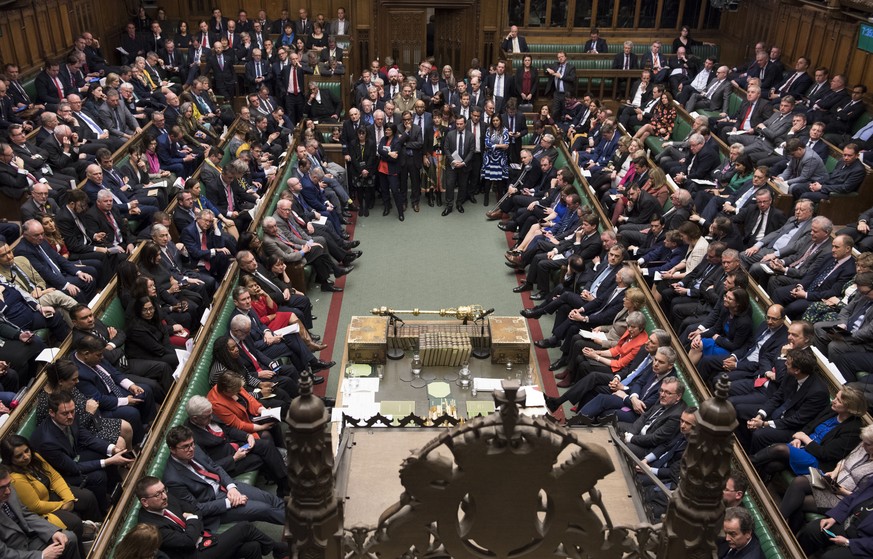 Britain&#039;s Prime Minister Theresa May sits on front bench right, orange jacket, facing a packed parliament Tuesday March 12, 2019. May keeps going, declining to resign, despite two successive parl ...