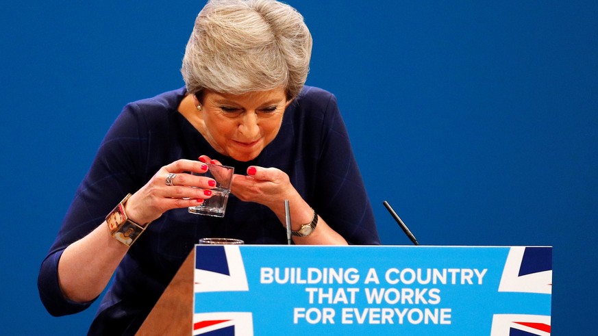 FILE PHOTO: Britain&#039;s Prime Minister Theresa May struggles with her glass of water after suffering a coughing fit whilst addressing the Conservative Party conference in Manchester, October 4, 201 ...