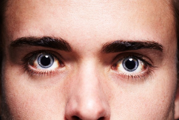 Closeup portrait of a young man&#039;s face with dilated pupils