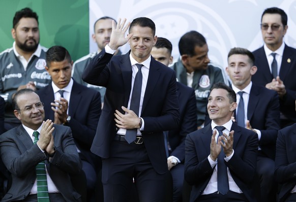 Mexican national soccer team player Javier &quot;Chicharito&quot; Hernandez waves as he is introduced during a ceremony where Mexican President Enrique Pena Nieto presented the national flag to the te ...