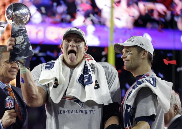 New England Patriots tight end Rob Gronkowski, left, and quarterback Tom Brady celebrate with the Vince Lombardi Trophy after the NFL Super Bowl XLIX football game against the Seattle Seahawks Sunday, ...