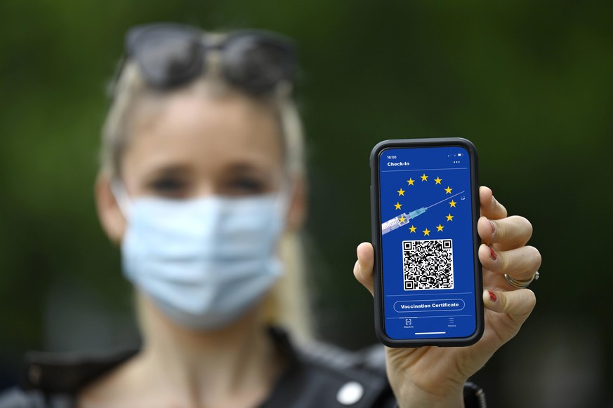 Symbolfoto Impfprivilegien, Frau zeigt Smartphone mit digitalem europ