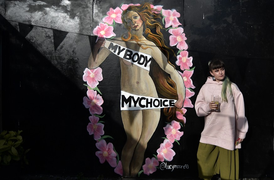 DUBLIN, IRELAND - MAY 13: A woman stands in front of a mural supporting the Yes vote located inside the Bernard Shaw pub on May 13, 2018 in Dublin, Ireland. The referendum on the abortion issue in Ire ...