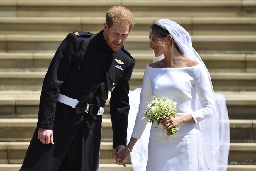 Britain&#039;s Prince Harry and his wife Meghan Markle walk down the west steps after their wedding ceremony at St. George&#039;s Chapel in Windsor Castle in Windsor, near London, England, Saturday, M ...