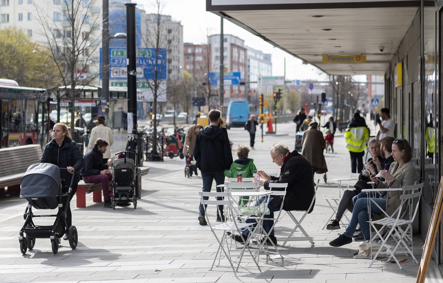 ARCHIV - 20.04.2020, Schweden, Stockholm: Menschen sitzen im Stadtzentrum vor einem Eiscafe. (zu dpa &quot;Verr