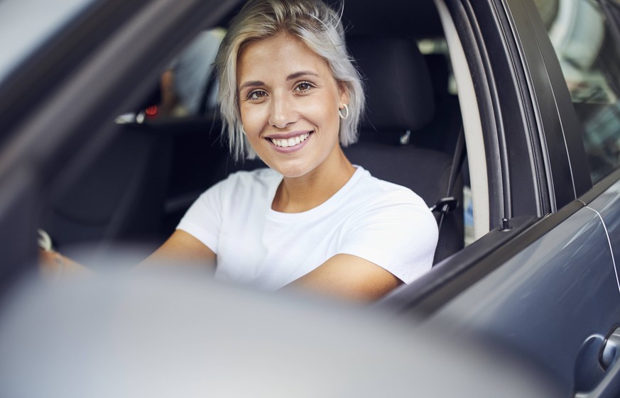 Young woman sitting in her car model released Symbolfoto PUBLICATIONxINxGERxSUIxAUTxHUNxONLY PNEF01145