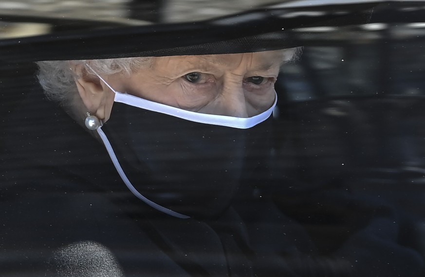 Britain&#039;s Queen Elizabeth II follows the coffin in a car as it makes it&#039;s way past the Round Tower during the funeral of Britain&#039;s Prince Philip inside Windsor Castle in Windsor, Englan ...