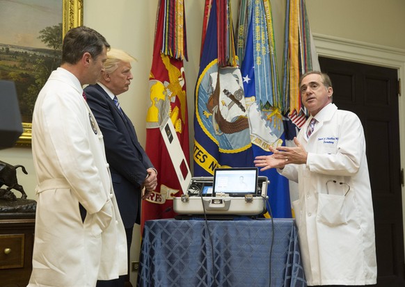 U.S. Veterans Affairs Secretary Dr.David Shulkin(right) explains equipment to White House Physician Dr. Ronny L. Jackson(left) U.S. President Donald Trump (2nd left) to be used in a new program using  ...