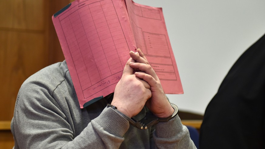 FILE - In this Feb. 26, 2015 file photo former nurse Niels Hoegel., accused of multiple murder and attempted murder of patients, covering his face with a file at the district court in Oldenburg, Germa ...