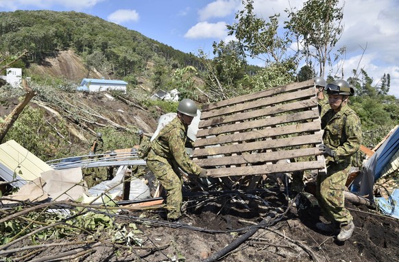 Japan Ground Self-Defense Force personnel search for missing persons at the site of a landslide triggered by a powerful earthquake in Atsuma town, Hokkaido, northern Japan, Thursday, Sept. 6, 2018. Se ...