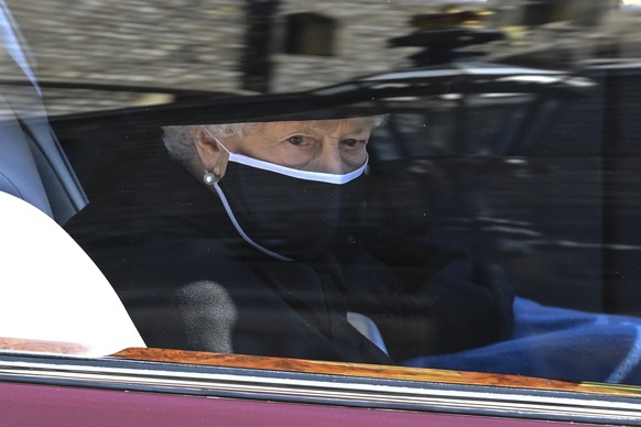 Britain&#039;s Queen Elizabeth II follows the coffin in a car as it makes it&#039;s way past the Round Tower during the funeral of Britain&#039;s Prince Philip inside Windsor Castle in Windsor, Englan ...