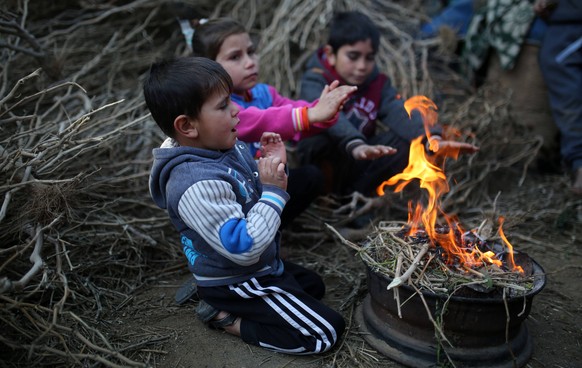 January 8, 2019 - Gaza, Palestine Territories, Palestine - Palestinian children sit together around a fire as they seek shelter from the cold, in a poor neighbourhood in Beit Lahia in the northern of  ...