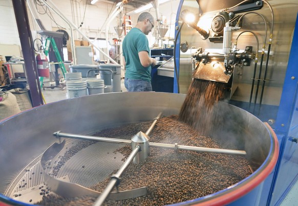 Bryan Rickert, a coffee roaster for Dubuque Coffee Company, monitors equiptment as beans begin to come out of a roaster, on National Coffee Day in Brentwood, Missouri on Tuesday, September 29, 2020. P ...