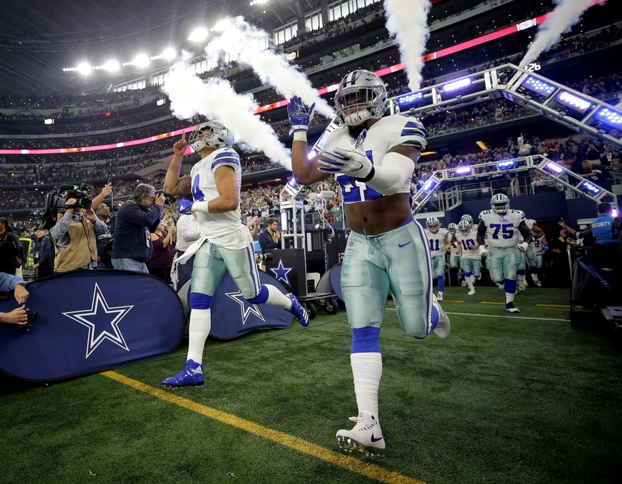 FILE PHOTO: Dallas Cowboys running back Ezekiel Elliott (21) and quarterback Dak Prescott (4) run onto the field before a game against the Seattle Seahawks at AT&amp;T Stadium in Arlington, Texas, U.S ...