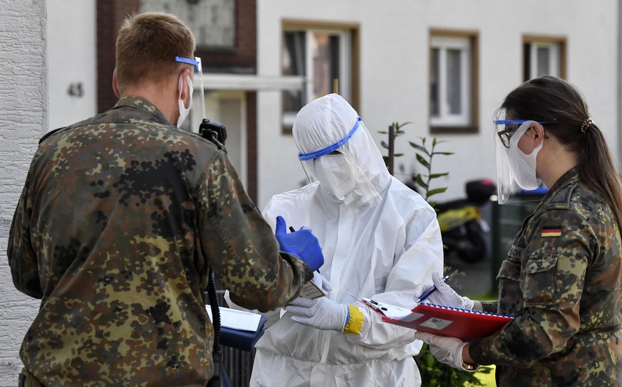 Medical staff and army members take COVID-19 tests of Toennies employees and their families who are quarantined behind fences in Verl, Germany, Tuesday, June 23, 2020. Following the corona outbreak at ...