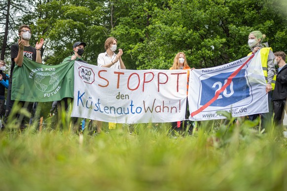 05.06.2021, Niedersachsen, Rastede: Einige Demonstranten halten bei einer Versammlung gegen den Bau der Autobahn A20 Banner mit den Aufschriften �Fridays for Future� und �A20 nie! Stoppt den K�stenaut ...