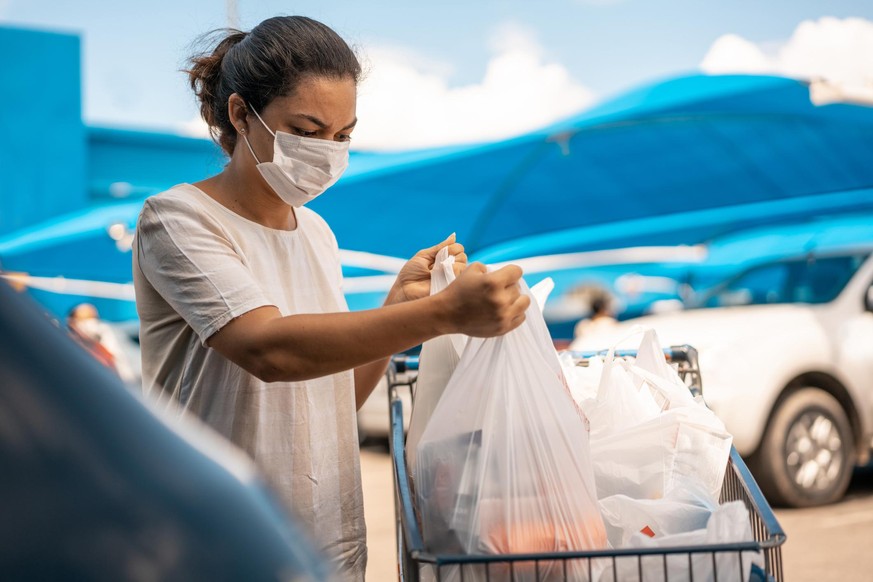 Woman finishing shopping at the supermarket during the COVID-19 pandemic in 2020