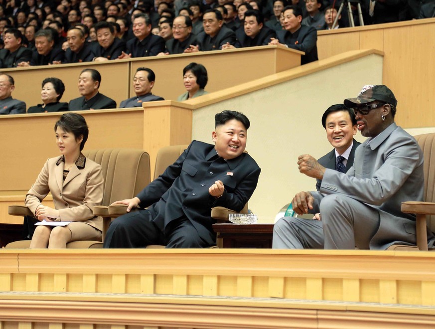 In this Jan. 8, 2014 photo provided by the North Korean government, North Korean leader Kim Jong Un, center, talks with former NBA player Dennis Rodman, right, as they watch an exhibition basketball g ...