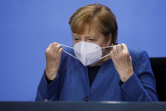 German Chancellor Angela Merkel (CDU) takes off her mask after a press conference at the Chancellery in Berlin, Wednesday, Oct. 28, 2020. Merkel is pressing for a partial lockdown as the number of new ...