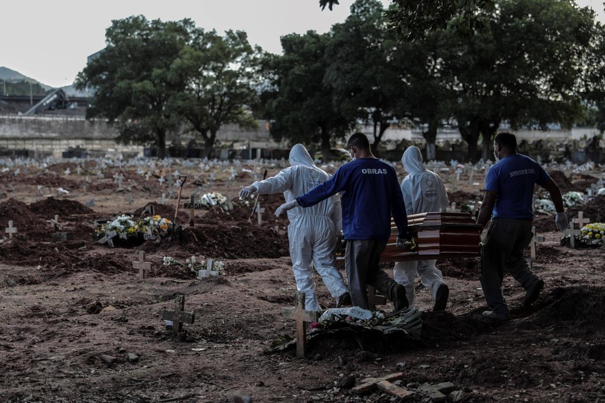Employees of a mortuary execute the burial of a person who died of COVID-19, in the Caju cemetery, in the northern area of Rio de Janeiro, Brazil, 08 May 2020. Rio de Janeiro has about seven million i ...