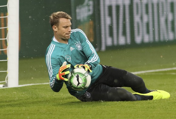 Germany goalkeeper Manuel Neuer catches a ball as hail falls during warmup before a friendly soccer match between Austria and Germany in Klagenfurt, Austria, Saturday, June 2, 2018. (AP Photo/Ronald Z ...