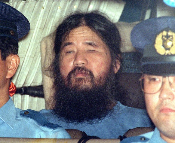 FILE - In this Sept. 25, 1995, file photo, cult leader Shoko Asahara, center, sits in a police van following an interrogation in Tokyo. Thirteen Japanese cult members may be sent to the gallows any da ...