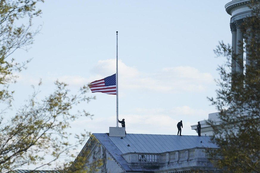 02.04.2021, USA, Washington: Die amerikanische Flagge am Kapitol wird auf halbmast gesetzt, nachdem ein Angreifer an einem Zugang zum Sitz des US-Kongresses mit einem Auto in zwei Polizisten gefahren  ...