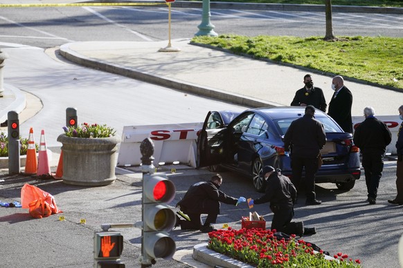 02.04.2021, USA, Washington: Beamte untersuchen den Tatort, nachdem ein Angreifer an einem Zugang zum Sitz des US-Kongresses mit einem Auto in zwei Polizisten gefahren ist. Nach dem Angriff auf das US ...