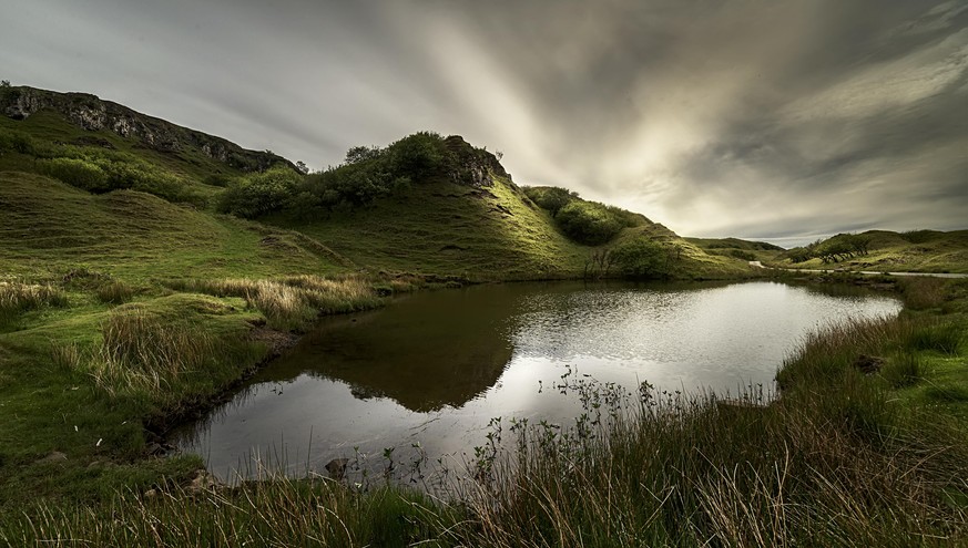 Small lagoon surrounded by grass under twilight in Fairy Glen, Sky Island, Scottish Highlands