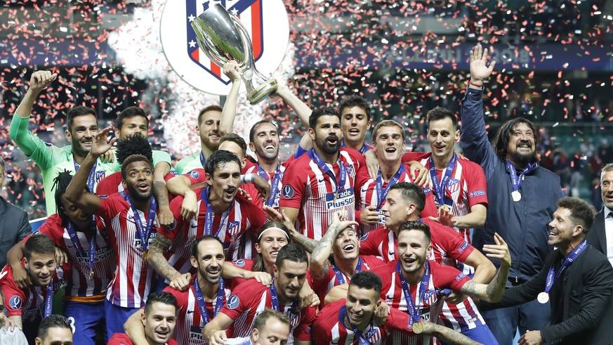 Atletico&#039;s team members celebrate with trophy after the UEFA Super Cup final soccer match between Real Madrid and Atletico Madrid at the Lillekula Stadium in Tallinn, Estonia, Wednesday, Aug. 15, ...