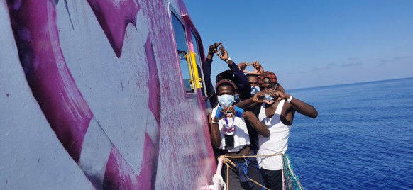 In this undated handout photo people pose for a photo after being rescued by the Louise Michel, a migrants search and rescue ship operating in the Mediterranean and financed by British street artist B ...