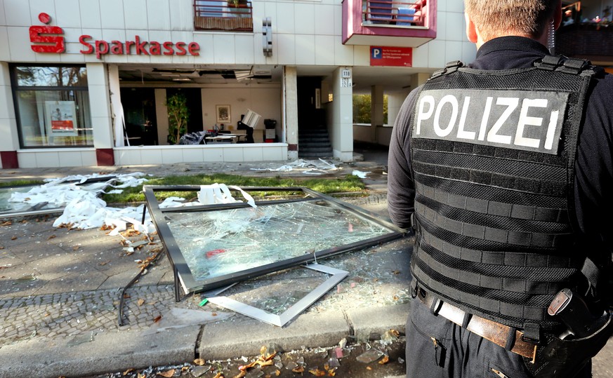Ein Polizist vor einer zerstörten Sparkassenfiliale in Berlin: In der Filiale war eine Explosion ausgelöst und Schließfächer ausgeräumt worden.