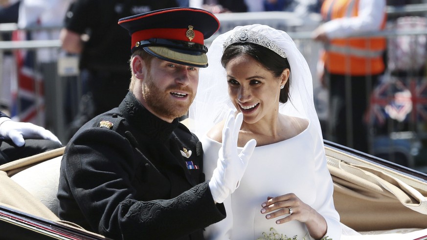 Britain&#039;s Prince Harry and Meghan Markle ride in an open-topped carriage after their wedding ceremony at St. George&#039;s Chapel in Windsor Castle in Windsor, near London, England, Saturday, May ...