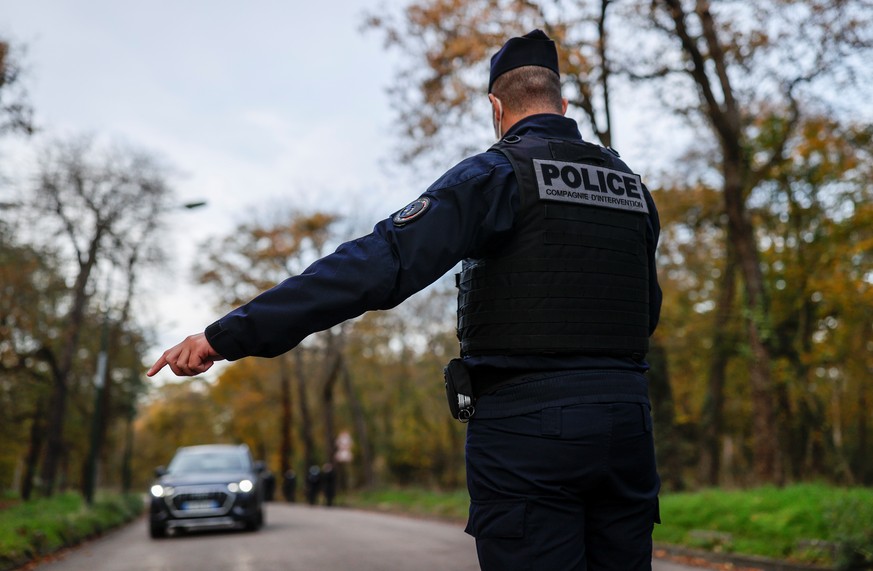 A French police officer stops a car to check exemption certificates and identity during the nationwide lockdown aimed at slowing the spread of the coronavirus disease (COVID-19), in the Bois de Boulog ...