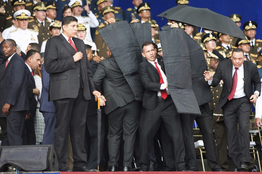 In this photo released by China&#039;s Xinhua News Agency, security personnel surround Venezuela&#039;s President Nicolas Maduro during an incident as he was giving a speech in Caracas, Venezuela, Sat ...