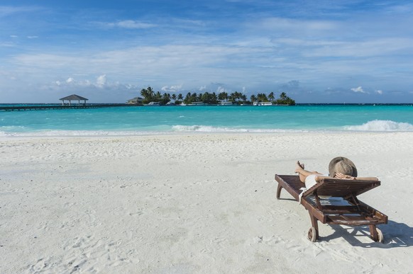 Maledives, Ari Atoll, Nalaguraidhoo, Sun Island Resort, back view of woman relaxing on the beach model released Symbolfoto PUBLICATIONxINxGERxSUIxAUTxHUNxONLY RUNF00729