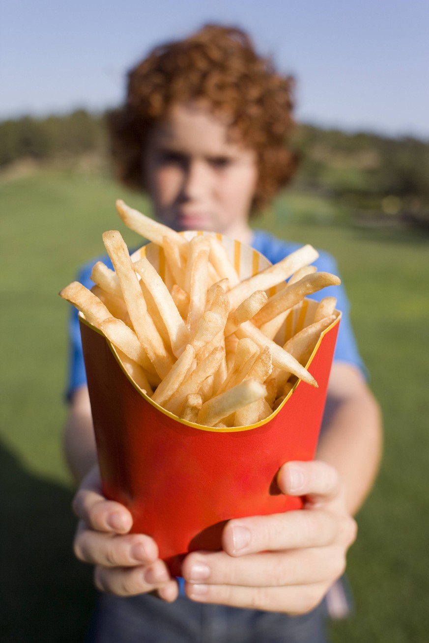 Boy holding chips MODEL RELEASED. Boy holding chips. These are fried chipped potato portions. They are a popular fast food item, but can contain large amounts of unhealthy saturated fats. Potatoes are ...