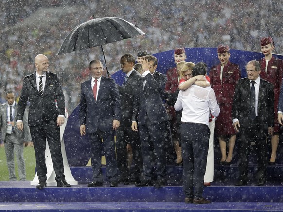 FIFA President Gianni Infantino, third left, gestures as Russian President Vladimir Putin stands underneath an umbrella as Croatian President Kolinda Grabar-Kitarovic greets Croatia head coach Zlatko  ...