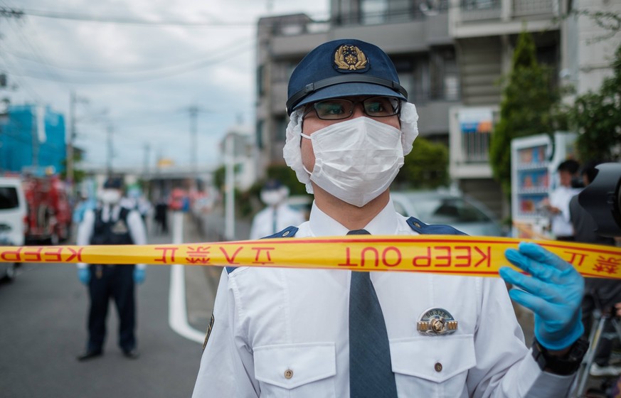 A police officer from Kanagawa prefecture stands to close a road after a mass stabbing close to Noborito station on May 28, 2019 in Kawasaki, Japan. According to media reports, 16 people, including el ...