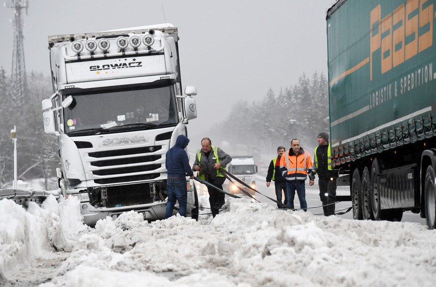 07.01.2019, Bayern, Holzkirchen: LKW-Fahrer versuchen an der Autobahn A8 ihre feststeckenden Fahrzeuge aus dem Schnee zu befreien. Foto: Tobias Hase/dpa +++ dpa-Bildfunk +++